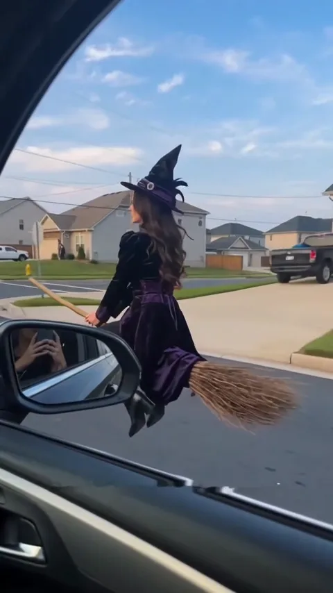 Broom rider beside a moving car